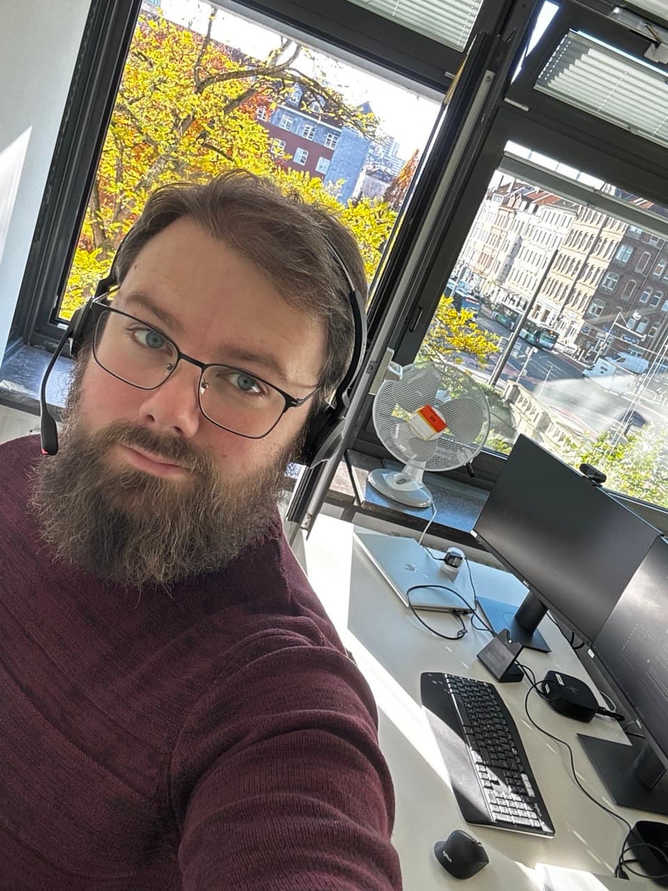 Marco Bartkowiak mit Brille und Headset an einem Computerarbeitsplatz
